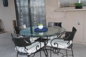 uma mesa de vidro com cadeiras e uma planta sobre ela em Cozy Home. em Phoenix