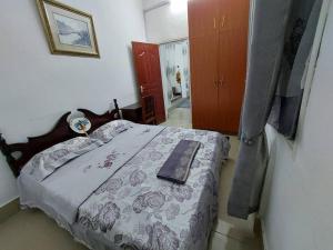 Mombasa Comfort House, Old Town في مومباسا: غرفة نوم بها سرير مع كتاب عليها