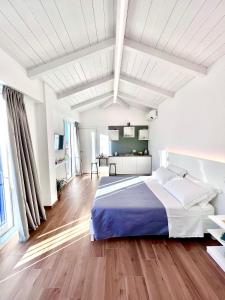 a white bedroom with a large bed and wooden floors at Tropea Il Tridente Accommodations in Tropea