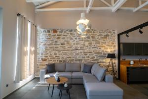 a living room with a couch and a stone wall at Seafront Karma Luxury - An Escape From Reality in Kato Gatzea