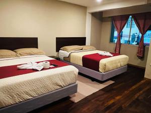 um quarto de hotel com duas camas com toalhas em Casa de Joss em Baños