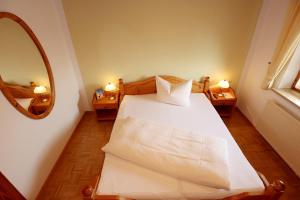 um quarto com uma cama branca e um espelho em Gasthof Rebland em Eichstetten