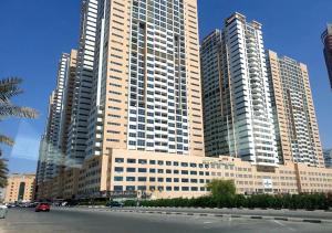 un grand bâtiment avec de grands gratte-ciel dans une ville dans l'établissement Elegant Room In shared Apartment, à Ajman