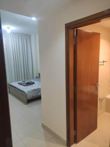 a door leading to a bedroom with a bed at Elegant Room In shared Apartment in Ajman 