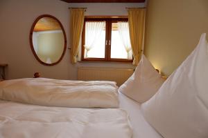 uma cama branca num quarto com um espelho em Gasthof Rebland em Eichstetten