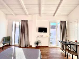 a living room with a table and a tv at Tropea Il Tridente Accommodations in Tropea