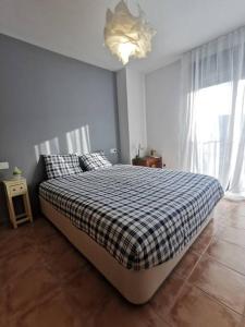 um quarto com uma cama com um cobertor xadrez em ENJOY VALDELINARES em Valdelinares