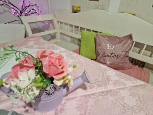 a vase of flowers on a table with a happy winter pillow at Duna-Lak Vendégház in Apostag