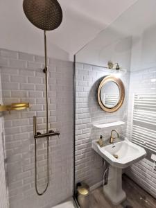 een witte badkamer met een wastafel en een douche bij L'exotic' 1 à 4 voyageurs in Perpignan