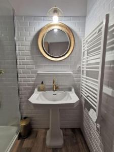 een witte badkamer met een wastafel en een spiegel bij L'exotic' 1 à 4 voyageurs in Perpignan