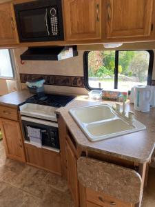a kitchen with a sink and a stove at 5th Wheel Trailer in Bere Alston
