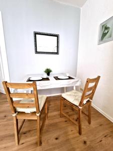 mesa de comedor con 2 sillas y mesa blanca en HappySide - Sm00th - Landhaustil - WLAN - Nespresso, en Leipzig