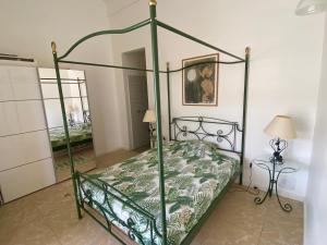 a bedroom with a four poster bed and a table at Chambre indépendante vue mer et montagne in Vieux-Habitants