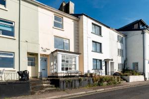 un edificio blanco al lado de una calle en The Sail House, en Brixham