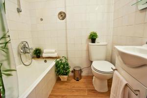 a bathroom with a toilet and a sink and a tub at Central Garden Saldanha Apartment in Lisbon