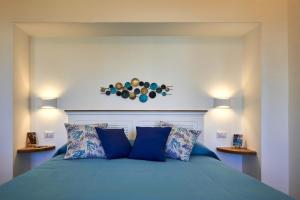 um quarto com uma cama azul com almofadas azuis em That's Amore Capri em Anacapri