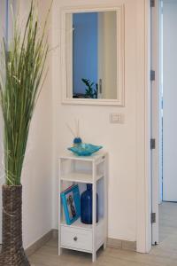 a white cabinet with a mirror and a plant at That's Amore Capri in Anacapri