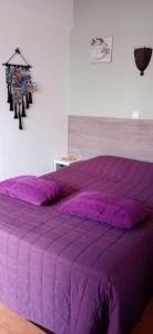 タヴィラにあるle Boucanierの- 紫色のベッド1台(紫色の掛け布団付)