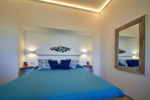 a bedroom with a blue bed and a mirror at That's Amore Capri in Anacapri
