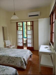 een slaapkamer met 2 bedden en een tafel en ramen bij Argo rooms in Ayios Nikitas