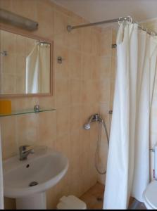 a bathroom with a sink and a shower curtain at Argo rooms in Agios Nikitas