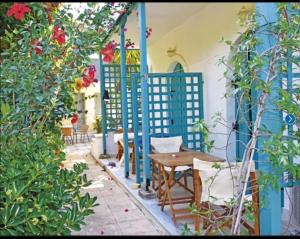 a patio with a table and chairs and flowers at Argo rooms in Agios Nikitas