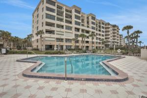 a swimming pool in front of a large apartment building at B110 Amelia Surf and Racquet in Fernandina Beach