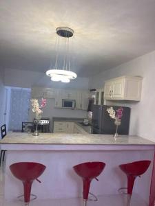 uma cozinha com um balcão com bancos vermelhos em Mount Royal Estate Cozy Comfort em Portmore