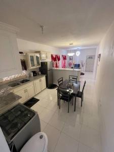 uma cozinha e sala de jantar com mesa e cadeiras em Mount Royal Estate Cozy Comfort em Portmore