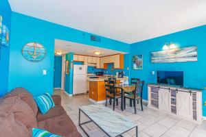 sala de estar y cocina con paredes azules y sofá en The Palace 705, en Myrtle Beach