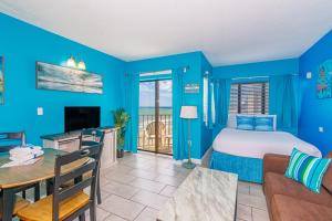 Schlafzimmer mit blauen Wänden, einem Bett und einem Tisch in der Unterkunft The Palace 705 in Myrtle Beach