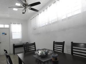comedor con mesa y ventilador de techo en Casa Del Sol-Unit A, en Bayamón