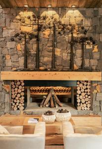 a stone fireplace with a table and two chairs at Hotel Alpestre in Gramado
