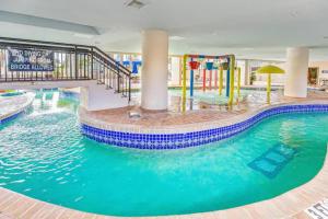 a swimming pool in a hotel with a water slide at Ocean Reef- Unique Oceanfront Condo-Free parking - Amazing pools in Myrtle Beach