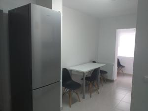 a kitchen with a white table and a refrigerator at Bellacasa in Zalău