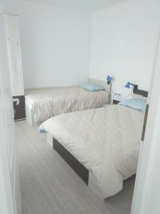 Habitación pequeña con 2 camas y paredes blancas. en Bellacasa en Zalău