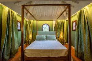 Cama en habitación con paredes verdes y ventana en Relais La Martina en Pietraviva