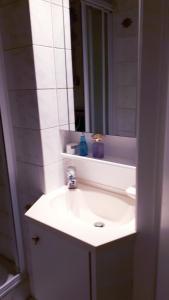 uma casa de banho com um lavatório branco e um espelho. em Shamrock Oostduinkerke em Oostduinkerke