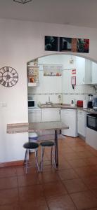 a kitchen with a table and two stools at le Boucanier in Tavira