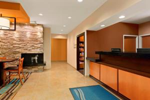 a lobby with a fireplace and a dining room at Fairfield Inn Racine in Racine