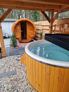 una gran bañera de hidromasaje en un patio trasero con cenador en CHALET HARMONY prive WELLNESS, en Putten