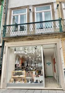 a shop front with a balcony on a building at Barão 35 Guest House in Braga