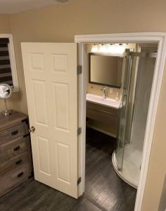 y baño con lavabo, ducha y espejo. en Cozy Furnished Apartment en Fort Simpson
