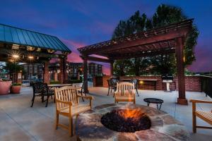 um pátio com uma fogueira e cadeiras e uma pérgola em TownePlace Suites by Marriott Tulsa Broken Arrow em Broken Arrow