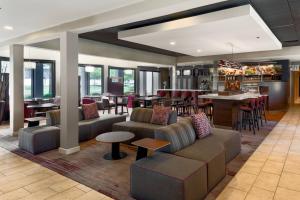 a restaurant with couches and tables and a bar at Courtyard Cincinnati Blue Ash in Blue Ash