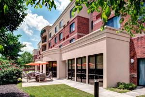 an exterior view of a building with tables and umbrellas at Courtyard Richmond North/Glen Allen in Richmond