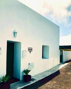 um edifício branco com uma porta e um sinal nele em Casita Volcan Lanzarote em Ye