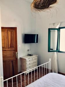 um quarto com uma cama e uma televisão na parede em Casita Volcan Lanzarote em Ye