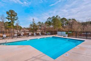 a swimming pool on a deck with a fence at Fairfield Inn & Suites by Marriott Atlanta Peachtree City in Peachtree City