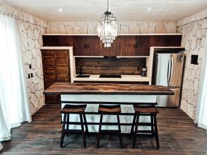 a kitchen with a counter and stools in a room at Kaaba Luum Jungle Villas in Chemuyil